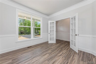 Unfurnished bedroom with crown molding, french doo