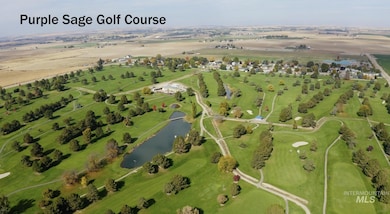 Aerial view of property and surrounding area with a nearby body of water and a golf course
