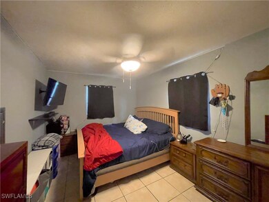Tiled bedroom featuring ceiling fan