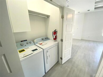 Laundry area with washer and clothes dryer and wood finish floors
