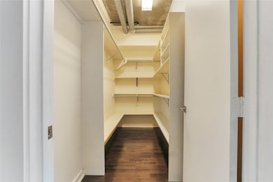 Spacious walk in closet with built in shelves for maximizing storage.