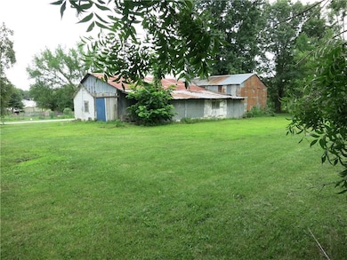 View of grassy yard featuring an outdoor structure and an outbuilding