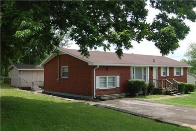 Side of home with view of the large storage shed in back.