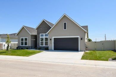 View of front of house with a gate, driveway, an attached garage, and a shingled roof