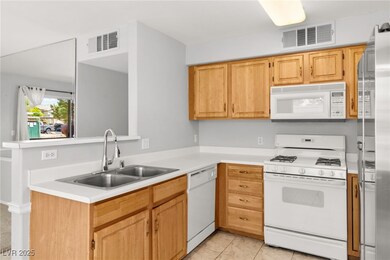 Kitchen featuring white appliances, light countert