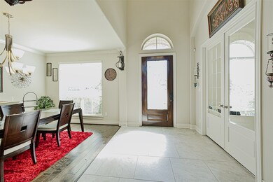 Another view of the two story entry and formal dining room.  The french doors to the right lead to a private office space.