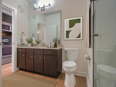 Bathroom with wood finished floors, toilet, baseb