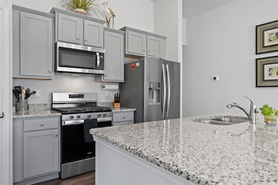 Kitchen with gray cabinets, a sink, stainless stee