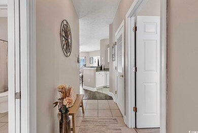 Hall featuring a textured ceiling and light tile p
