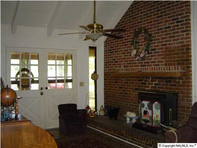 16' x 15' greatroom with a vaulted ceiling, fireplace and a ceiling fan.