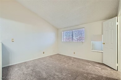 Empty room with carpet flooring, a textured ceilin