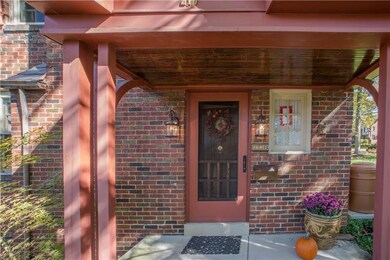 The welcoming covered front porch has twin lantern