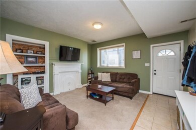 The ceramic tile entry flows into the cozy living 