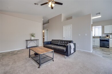 Living room featuring a ceiling fan, light carpet,