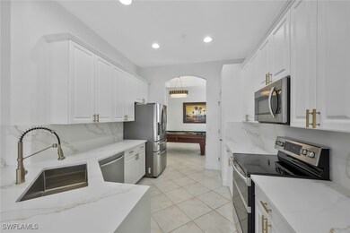 Kitchen featuring white cabinets, backsplash, stai