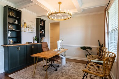 Home office with dark wood-style floors, a chandelier, crown molding, beamed ceiling, and coffered ceiling