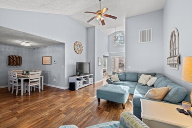 Living room featuring ceiling fan, dark hardwood /