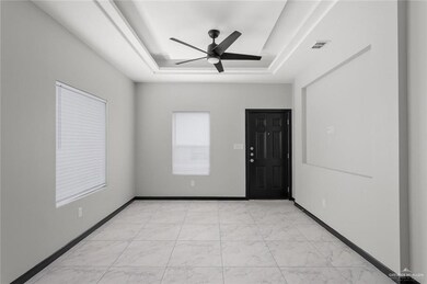 Entryway featuring a raised ceiling and a ceiling fan