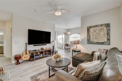 Living area featuring a ceiling fan and light wood