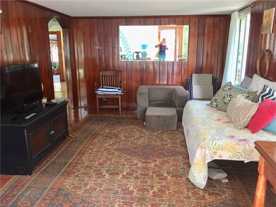 Living room has rustic wood walls.