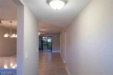 Hall with a chandelier and light tile patterned floors