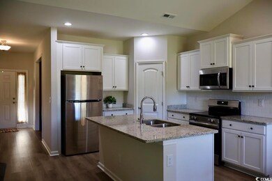 Kitchen featuring appliances with stainless steel finishes, a sink, white cabinets, tasteful backsplash, and recessed lighting