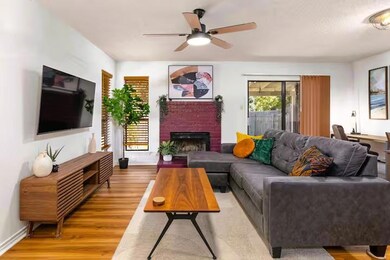 Living room with ceiling fan, wood finished floor