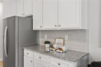 Kitchen with light stone counters, tasteful backsp