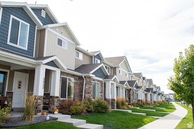 View of property exterior with a residential view, stone siding, a lawn, board and batten siding, and covered porch