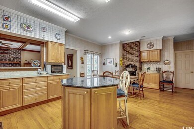 Kitchen with wallpapered walls, a brick fireplace,