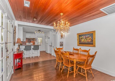 Dining area with visible vents, a chandelier, wood