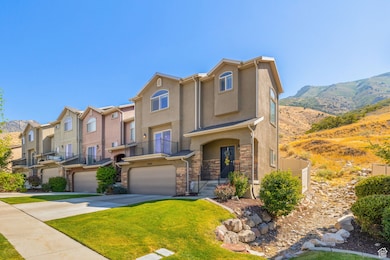 View of front of home with driveway, stucco siding, an attached garage, stone siding, and a residential view