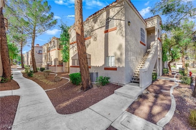 View of side of home with stairway, stucco siding, a tiled roof, and a residential view