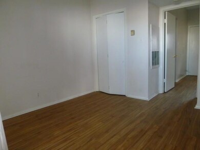 Unfurnished room featuring baseboards and wood fi