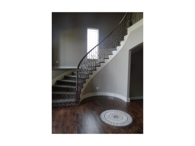 Sweeping Staircase and Tile Inlay at Entry