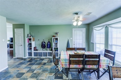 Dining area with baseboards, a textured ceiling, v