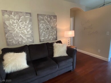 Living area featuring wood  floors and arched walk