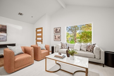 Living area featuring wood finished floors, beamed ceiling, and high vaulted ceiling