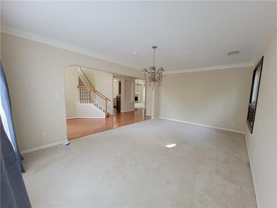 Unfurnished living room featuring carpet, a chand