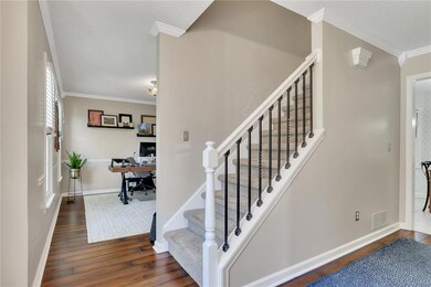 Bright and welcoming entry with stylish iron-railed staircase.
