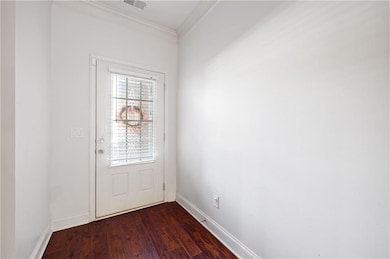 Doorway to outside with ornamental molding and hardwood / wood-style floors