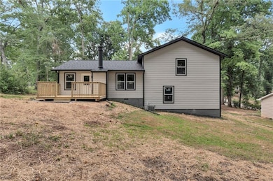 Back of property featuring crawl space, a wooden deck, a yard, and roof with shingles