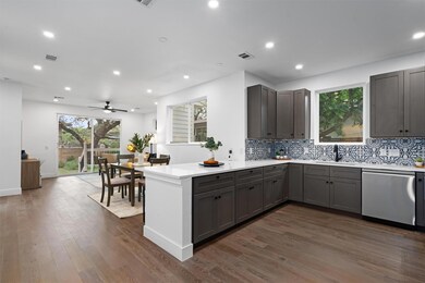 Kitchen with dishwasher, a peninsula, gray cabine