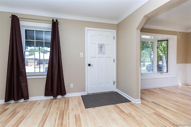 Entrance foyer with light wood-type flooring and arched walkways