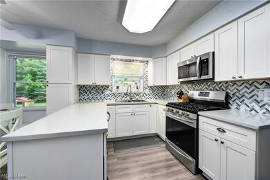 Kitchen featuring stainless steel appliances, sink, plenty of natural light, and light hardwood / wood-style flooring
