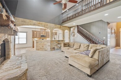 Living room with ceiling fan and a stone fireplace