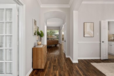Hallway featuring dark wood-type flooring and ornamental molding