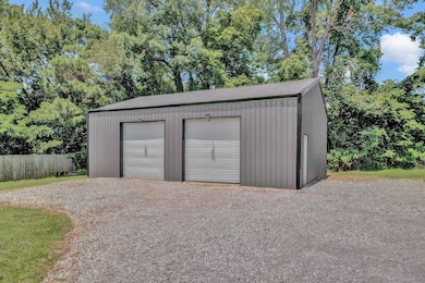 Detached garage featuring gravel driveway