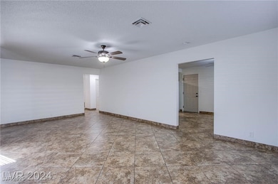 Spare room with a textured ceiling, a ceiling fan,
