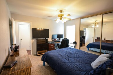 Carpeted bedroom with a closet and ceiling fan